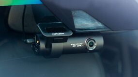 A dashcam installed in a vehicle on the front windshield