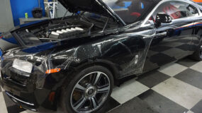 A black vehicle with a scratched up paint job