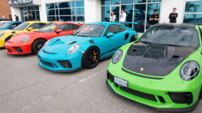 Various Porsche vehicles lined up outside an auto dealership
